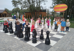 Dzieci stoją na szachownicy