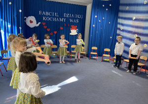 Dzieci śpiewają piosenkę z wykorzystaniem rekwizytu.